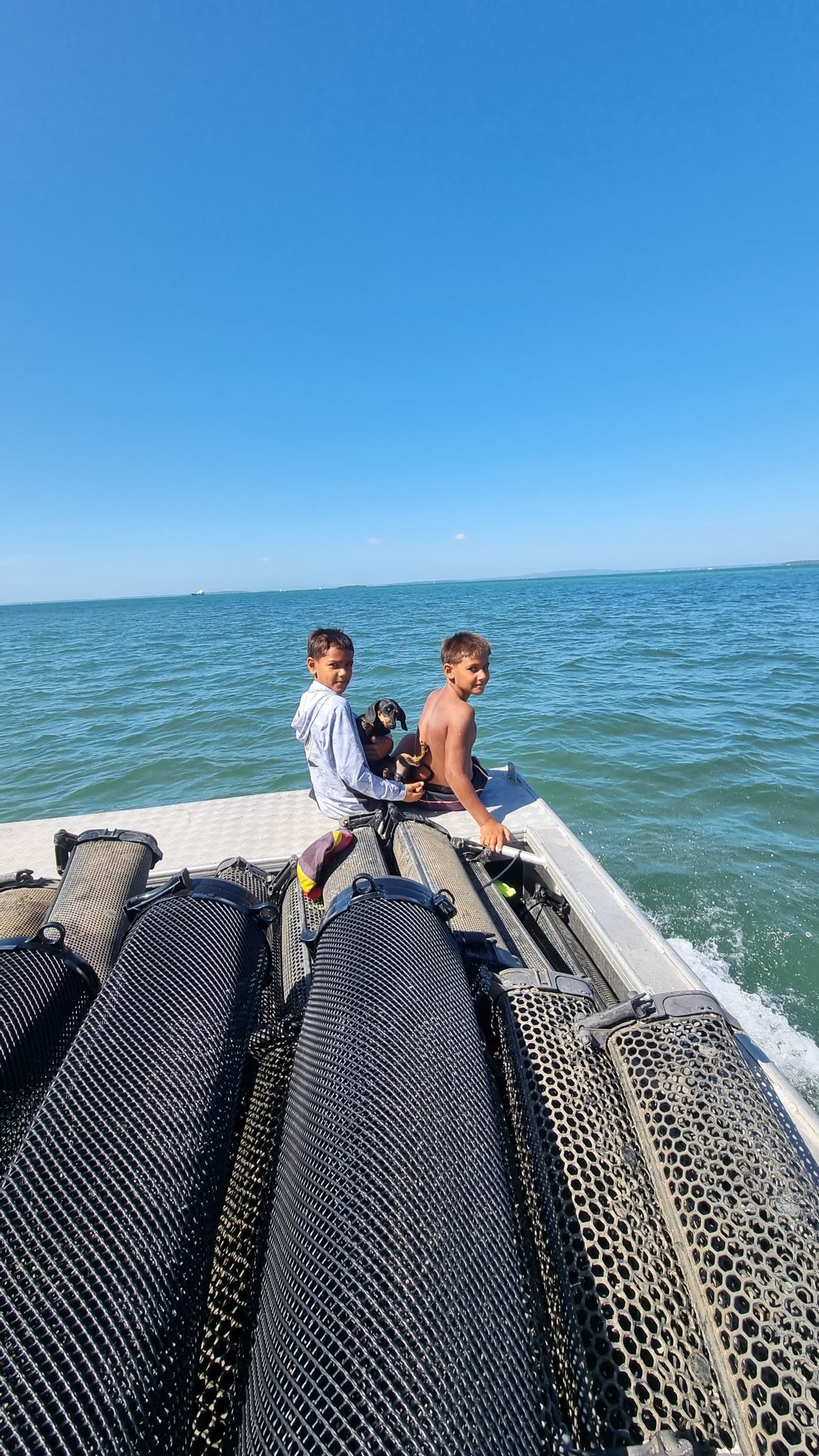 Children on the boat beside oyster baskets